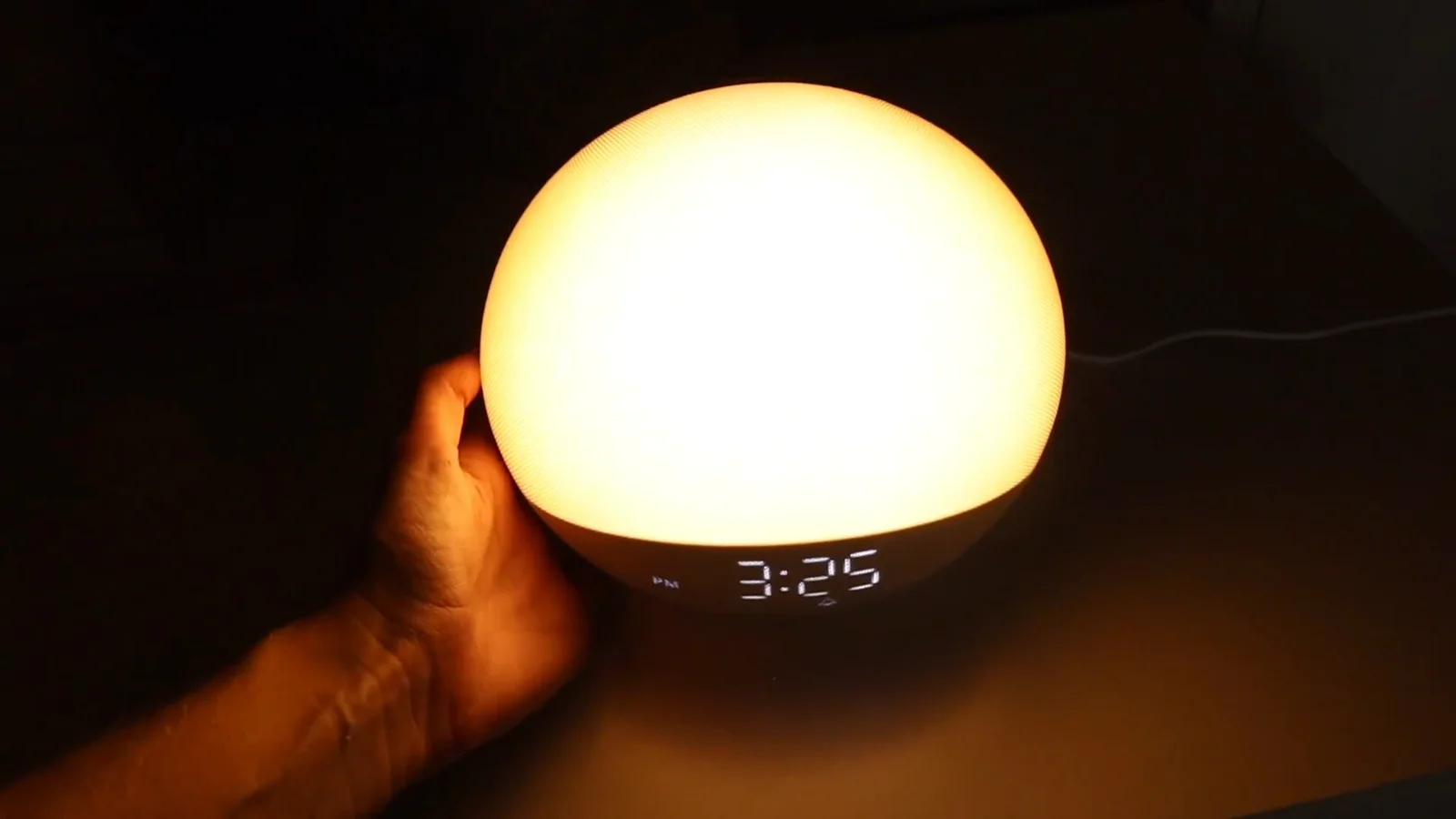 An Odokee H03 sunrise light at full brightness in a dark bedroom